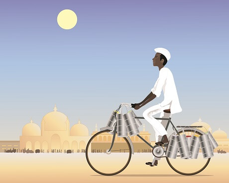 man riding bike in desert carrying containers