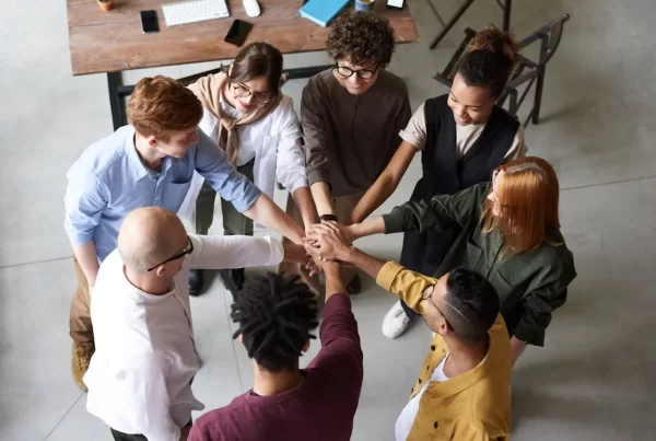 work team members in huddle with hands together in the middle
